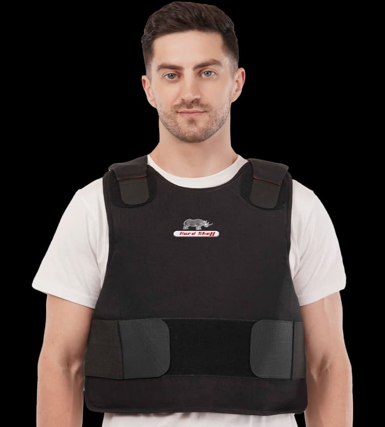 Man wearing black ballistic body armor vest over a white t-shirt, front view, lightweight protective vest for tactical and security use.